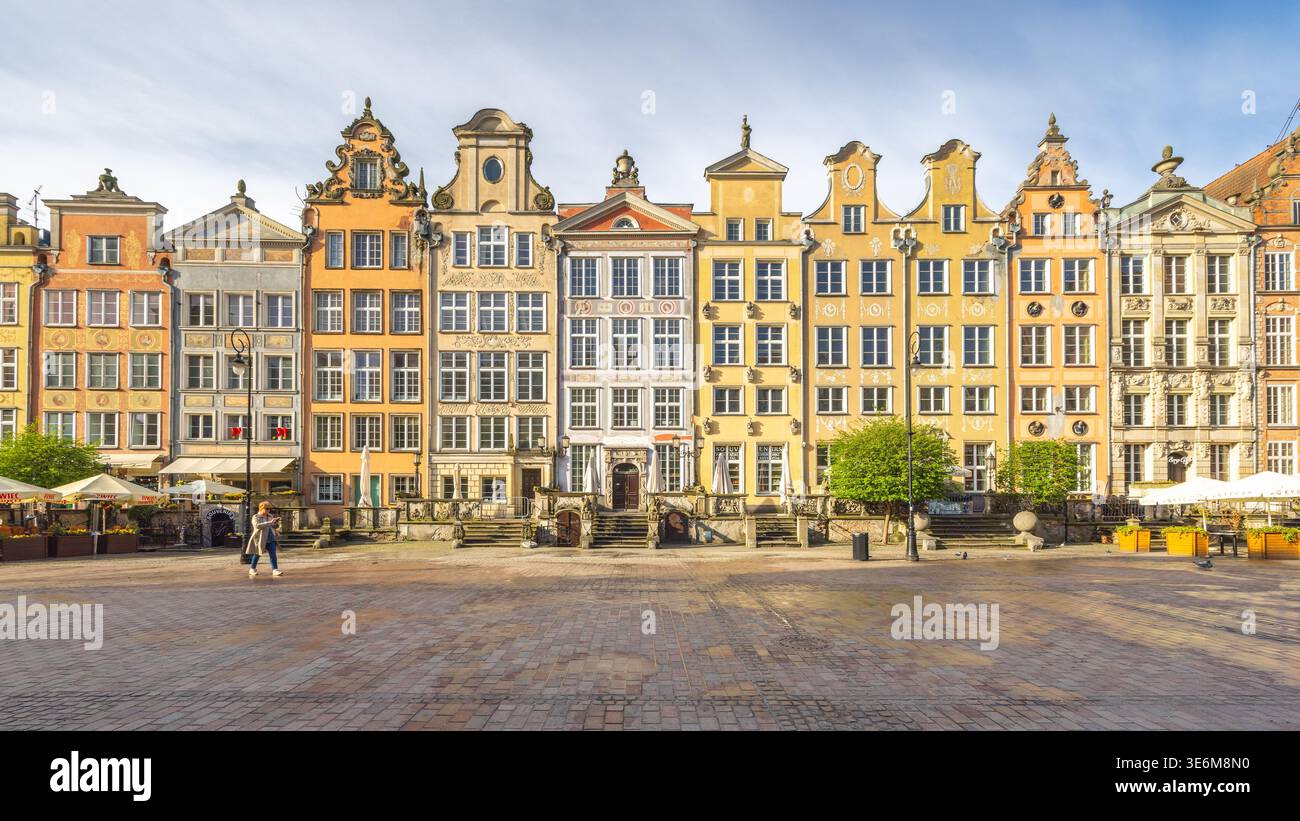 Danzica, Polonia - 2 maggio 2025: La piazza del mercato lungo. Edifici storici colorati fiancheggiano una piazza acciottolata in una città europea. Una persona attraversa Foto Stock