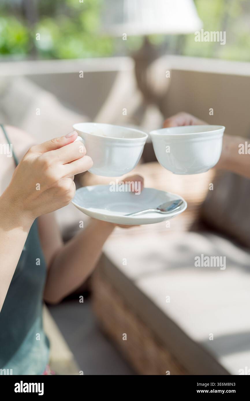 Dolce scena mattutina con tè fumante e compagnia amichevole Foto Stock