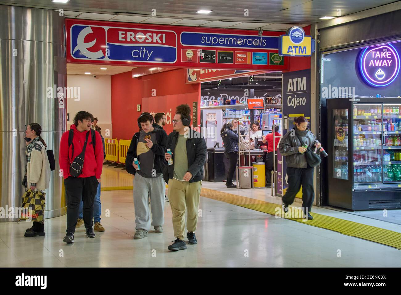 Maiorca. Spagna - 7 aprile 2026: Le persone passano davanti a un supermercato Eroski City all'Estacio Intermodal di Palma. I viaggiatori e la gente del posto visitano il Foto Stock