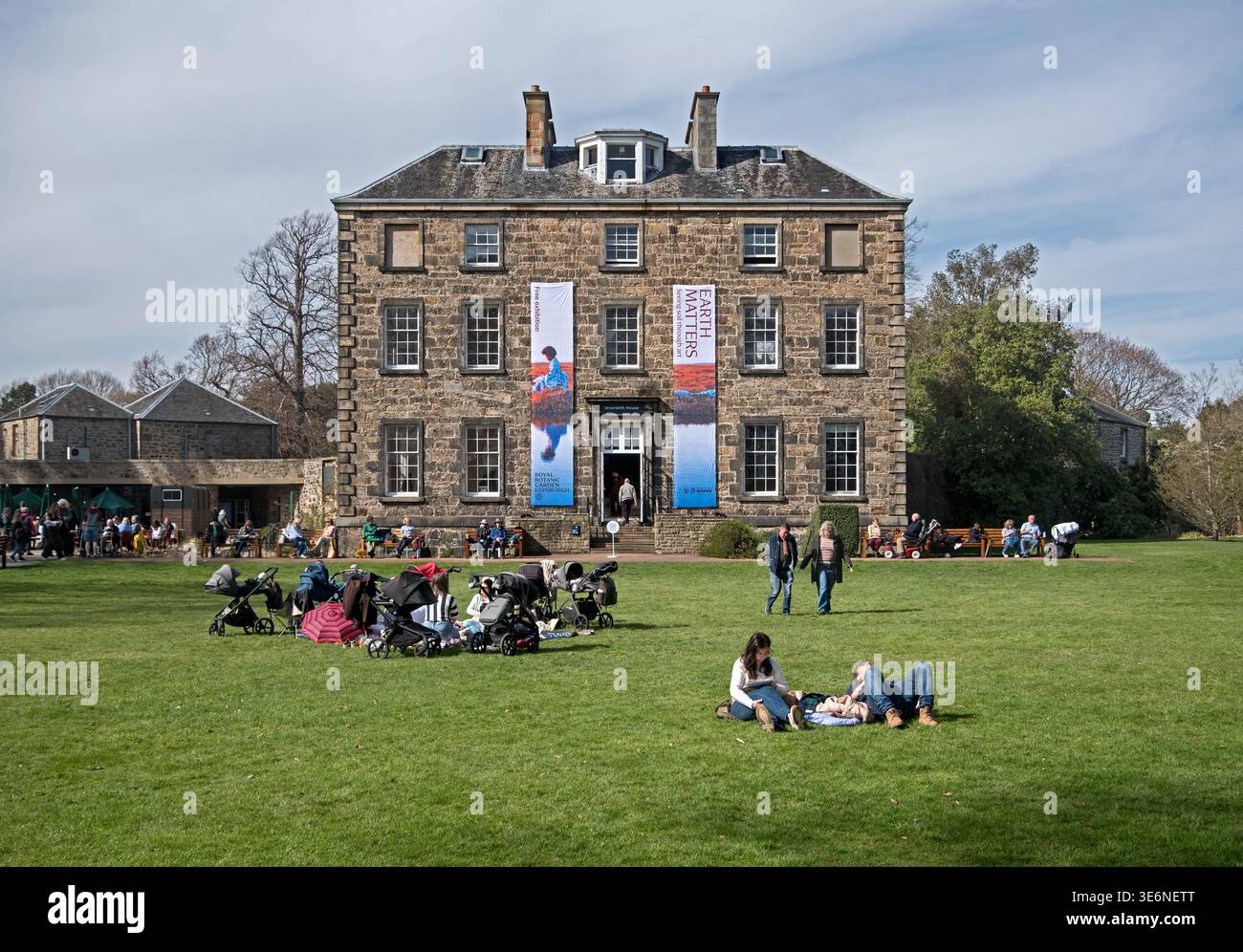 I visitatori godono del sole primaverile di fronte a Inverleith House, nei giardini dei Royal Botanic Gardens, Edimburgo, Scozia, Regno Unito. Foto Stock
