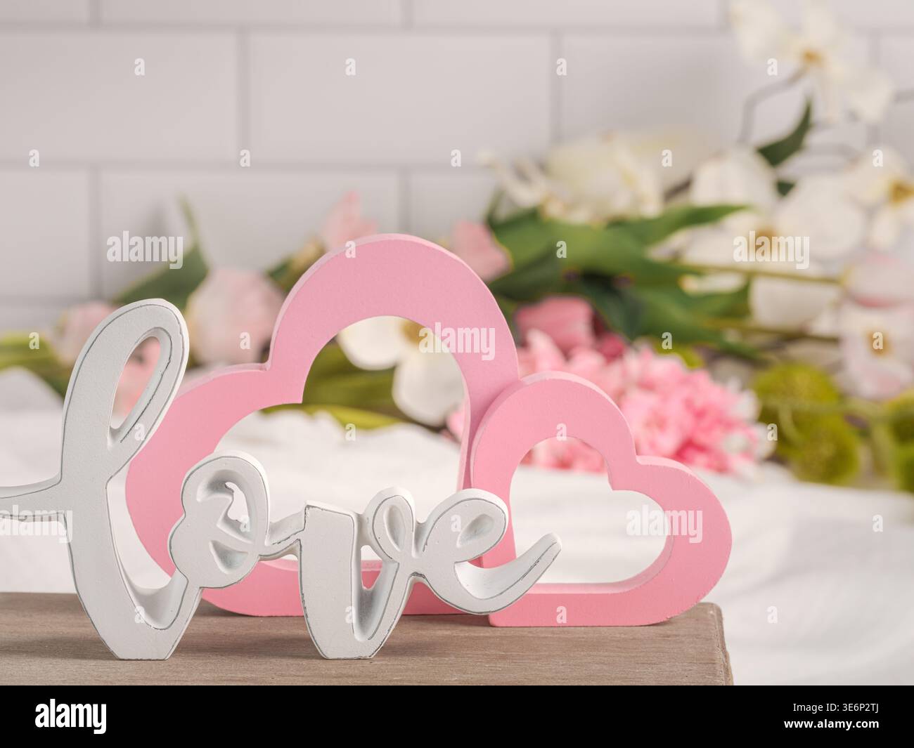I cuori rosa di San Valentino e il bianco AMANO il testo corsivo con lo sfondo dei fiori primaverili su sfondo piastrellato. Personalizza la carta personalizzata per San Valentino Foto Stock