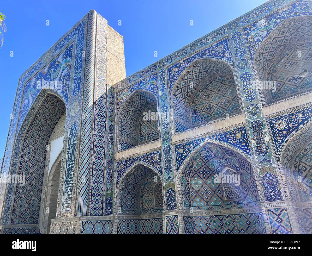 Vista dall'angolo basso dei dettagli della facciata islamica riccamente piastrellata nel complesso poi-Kalyan a Bukhara, Uzbekistan. - Immagine stock catturata con smartphone