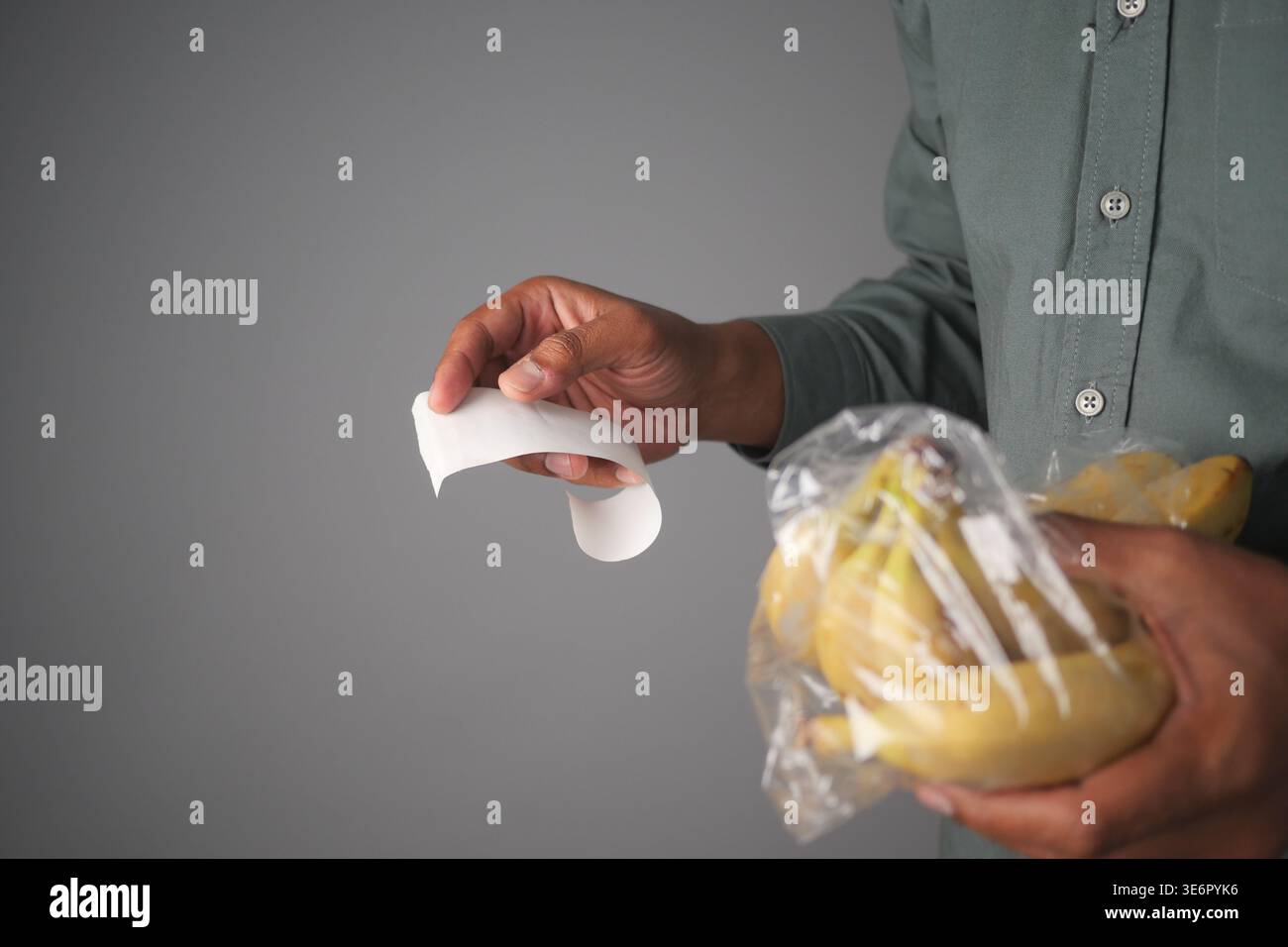 Persona che detiene banane e ricevuta Foto Stock