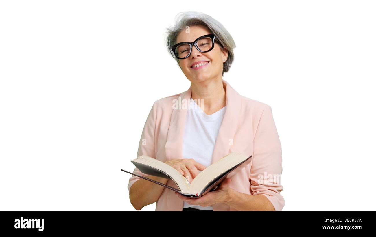 Donna matura sorridente che legge un libro con gli occhiali Foto Stock