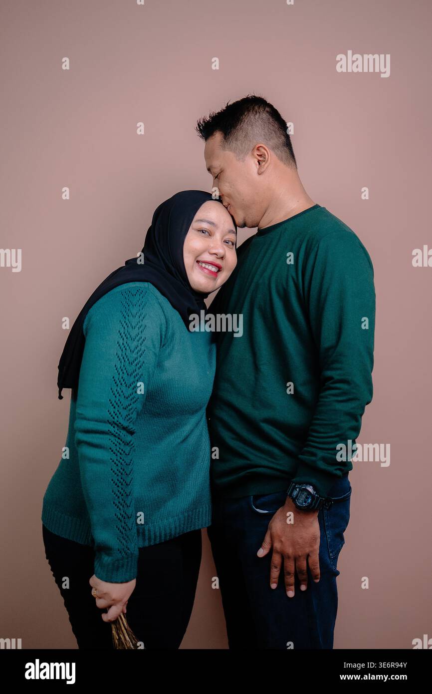 Un caldo abbraccio tra una coppia sorridente Foto Stock