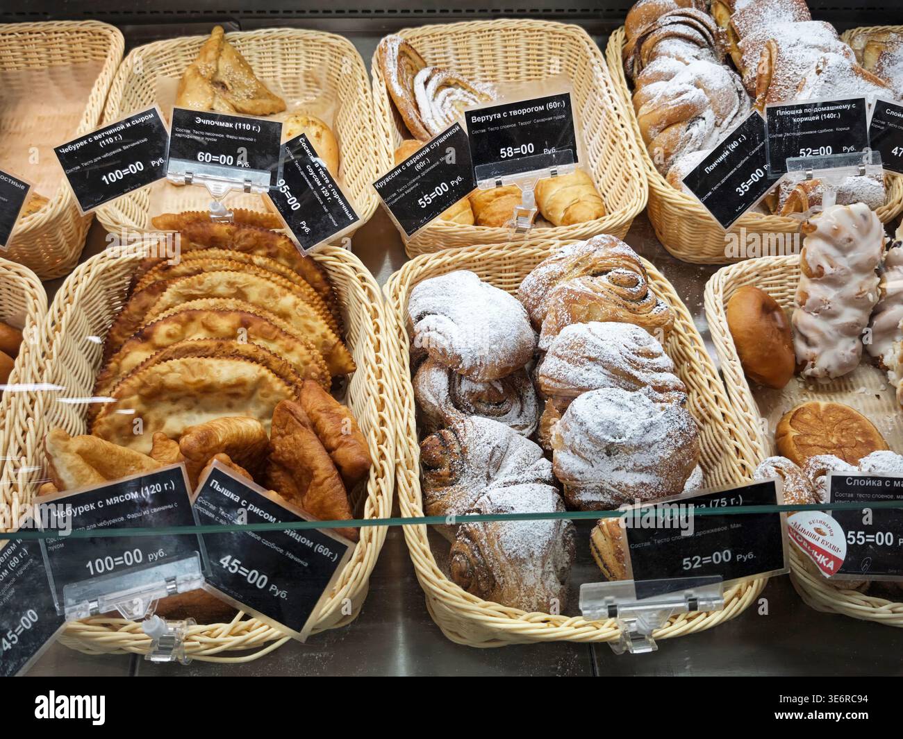 Kirov, Russia - 24 gennaio 2026: I clienti possono sfogliare una varietà di articoli da forno collocati in cesti in un negozio. I lavoratori organizzano pasticceria e pane in vendita. Foto Stock