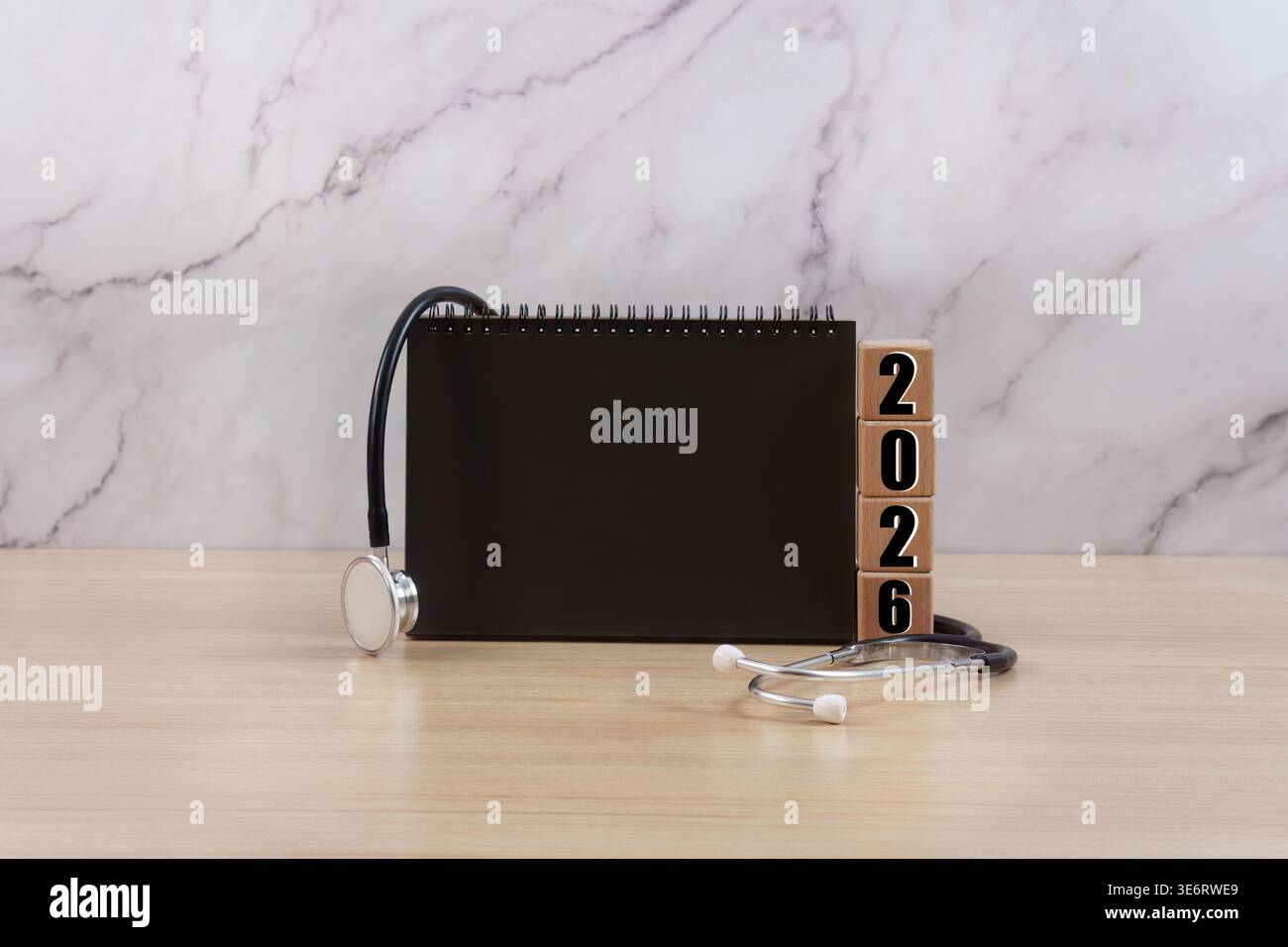 Stetoscopio e 2026 blocchi con taccuino su sfondo in marmo Foto Stock