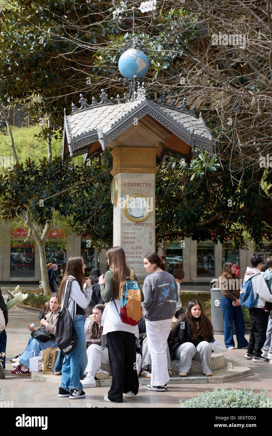 Maiorca. Spagna - 8 aprile 2026: Giovani seduti presso la storica colonna Higrometro a Placa d Espanya. I loghi visibili includono Fnac, Santander Work Cafe, Foto Stock