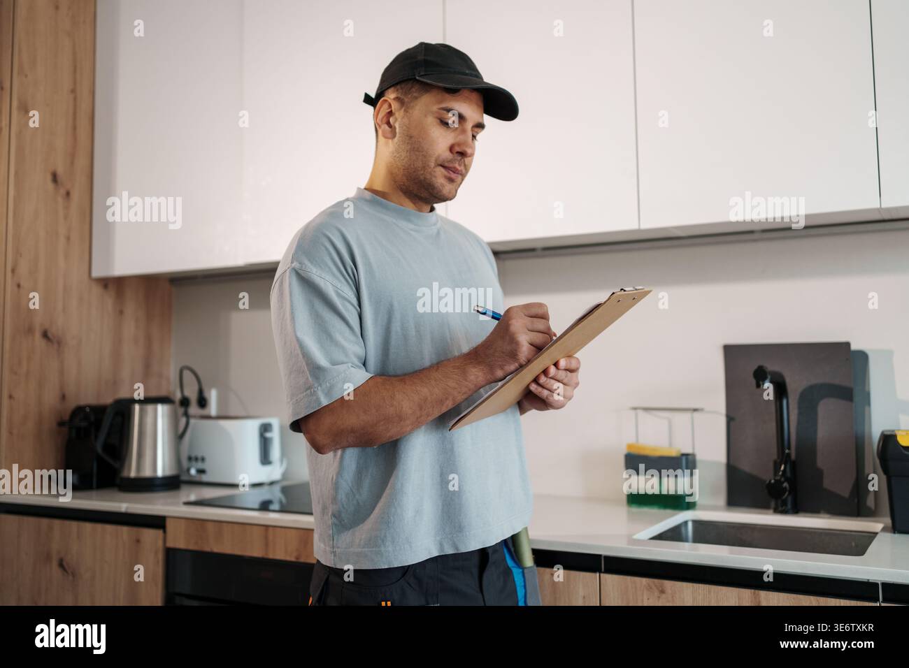 Il tecnico registra sistematicamente le osservazioni durante la valutazione e il test completi degli elettrodomestici da cucina Foto Stock
