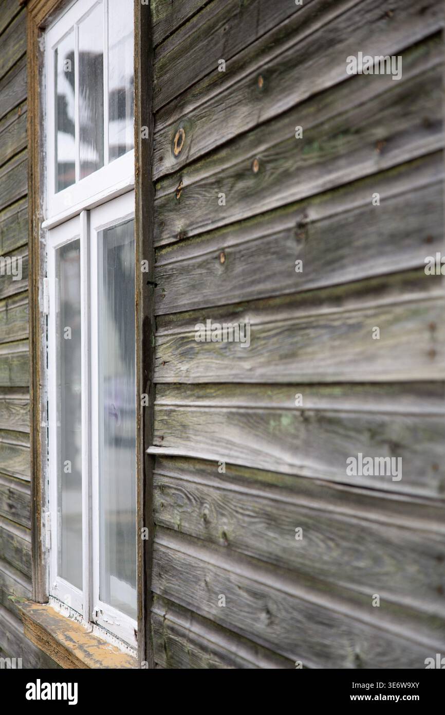 Vecchia casa in legno con finestre bianche, dettagli rustici esterni Foto Stock