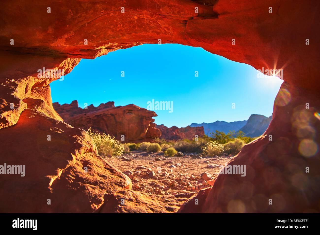 Fai un salto attraverso Red Rock Arch con paesaggi desertici e montagne Foto Stock