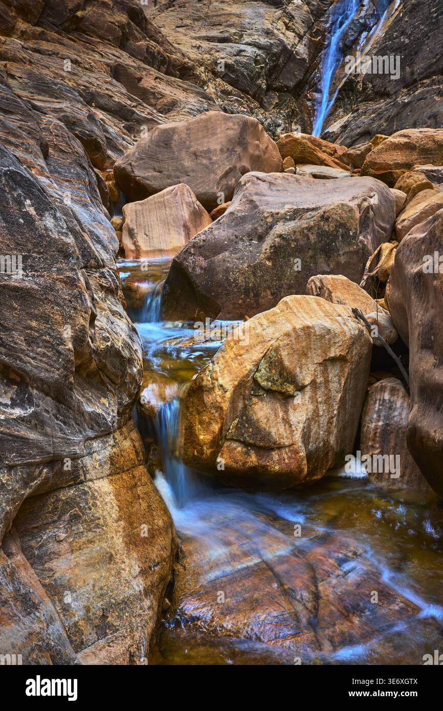 Cascata invernale che scorre attraverso i massi di arenaria nel Rugged Canyon Foto Stock