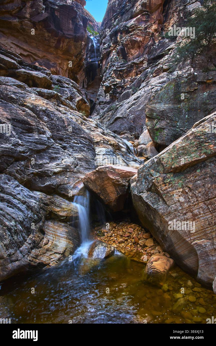 Cascata e piscina del Red Rock Canyon tra le scogliere robuste in luce invernale Foto Stock