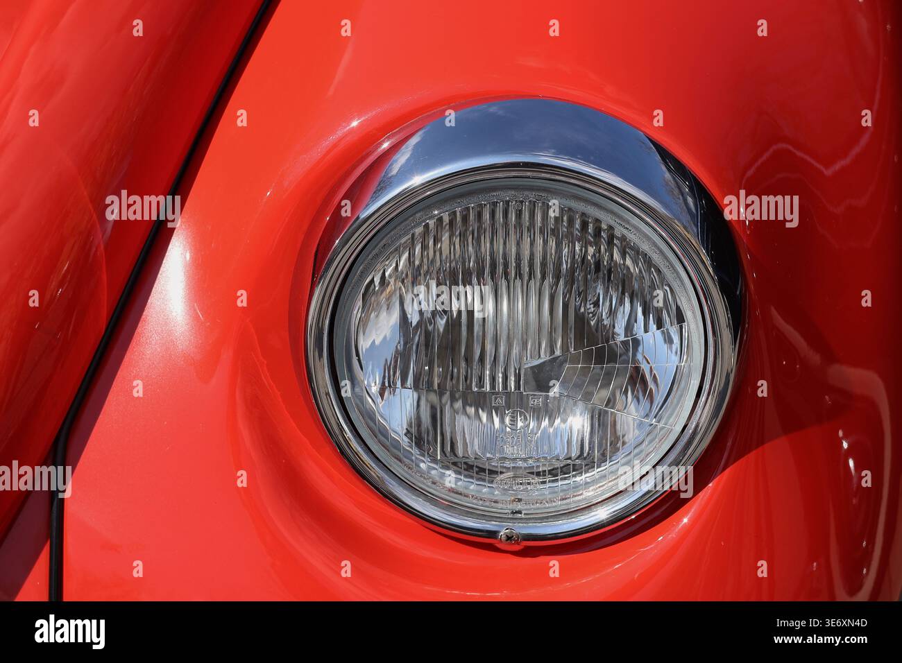 Primo piano di un'auto rossa d'epoca davanti con fari rotondi bianchi Foto Stock