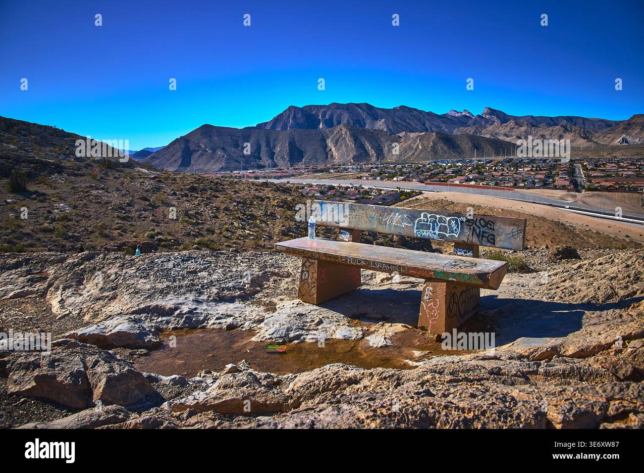 Graffiti Bench con vista su Lone Mountain e Las Vegas Suburbs sotto il cielo blu Foto Stock
