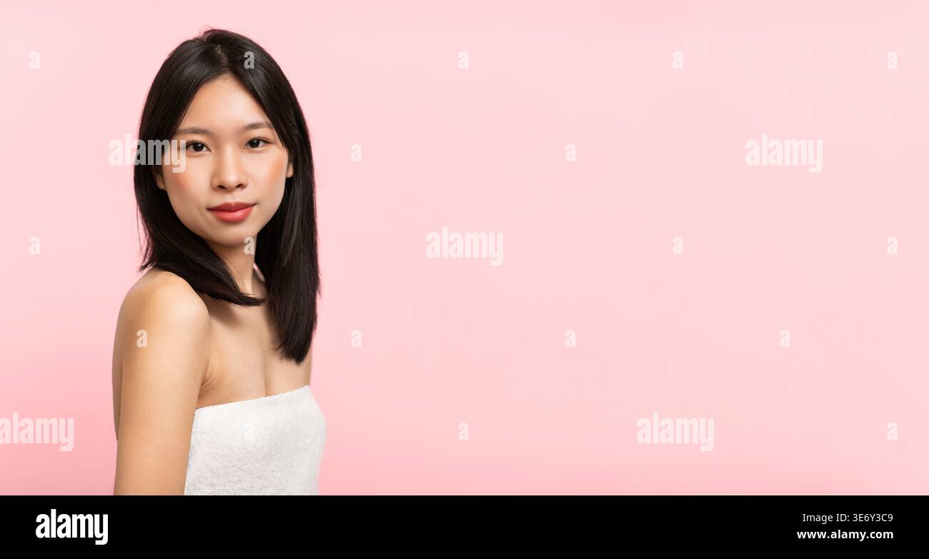 Donna in semplice Top bianco che posa su uno sfondo rosa durante le ore diurne Foto Stock