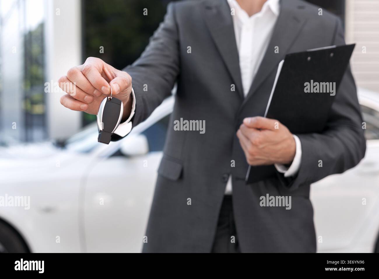Vendita di auto. Consulente con documenti che forniscono la chiave della vettura rispetto a quella automatica Foto Stock