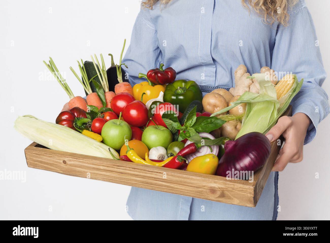 Mani femminili che tengono un asse di legno con verdure varie Foto Stock