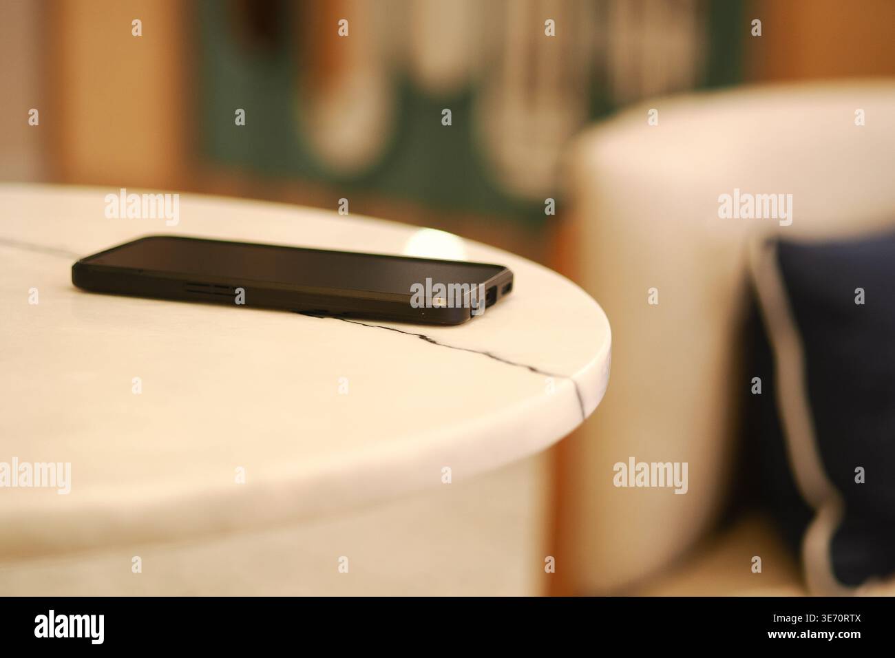 Smartphone su tavolo in marmo nel moderno soggiorno Foto Stock
