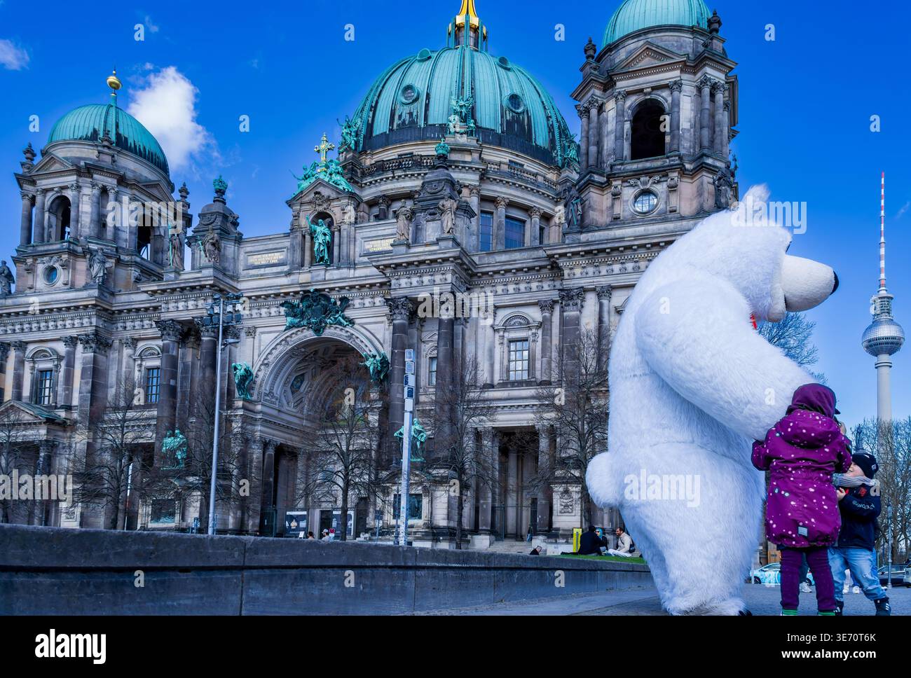 Bambini che interagiscono con una persona in costume da orso polare di fronte alla cattedrale di Berlino (Berliner Dom) a Berlino, Germania. Foto Stock