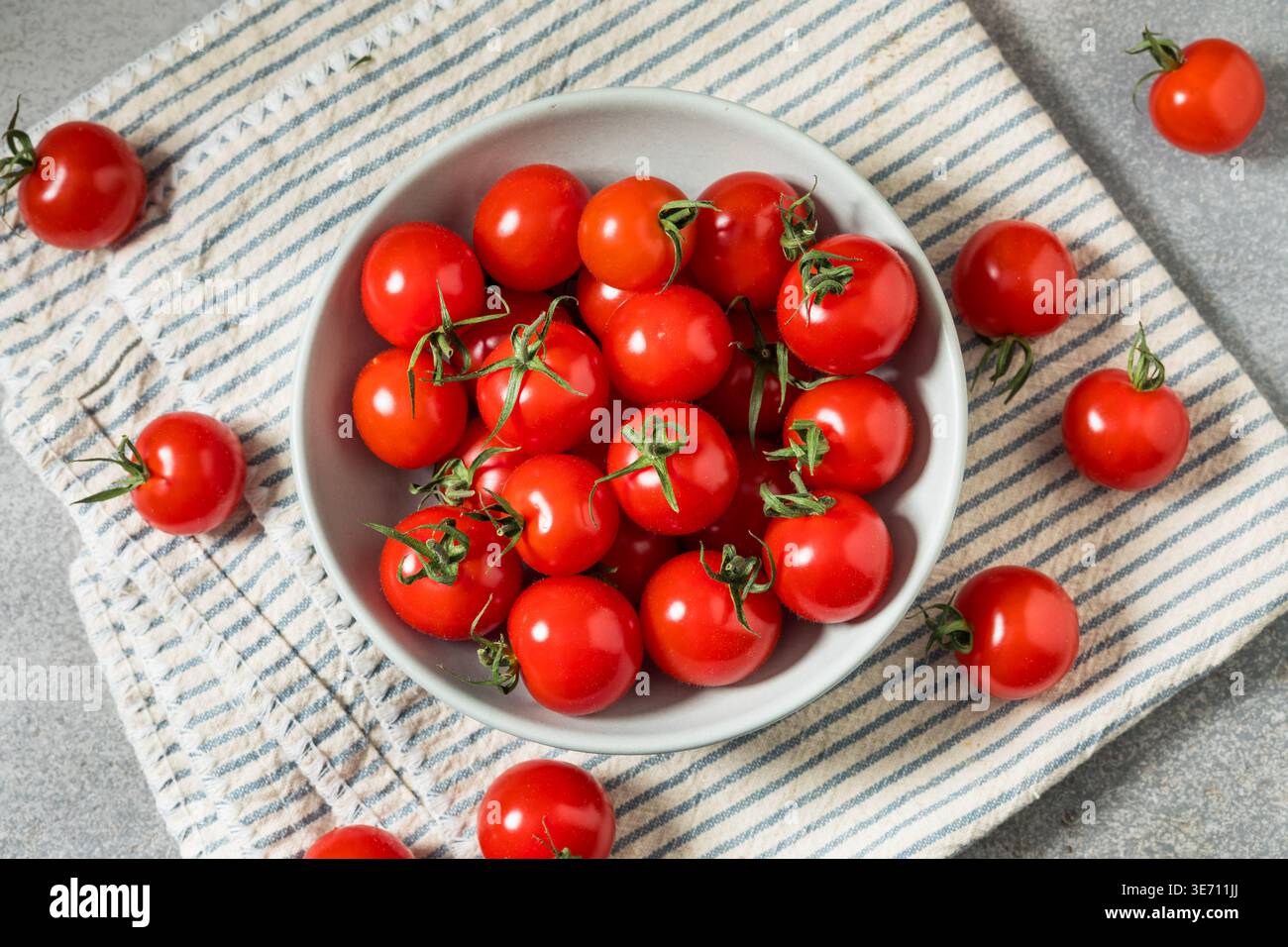 Pomodori rossi ciliegini crudi biologici in una ciotola Foto Stock
