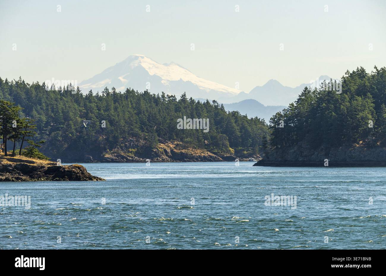Teleobiettivo del monte Baker a distanza nebbiosa attraverso il passo di ostruzione nelle isole San Juan di Washington Foto Stock