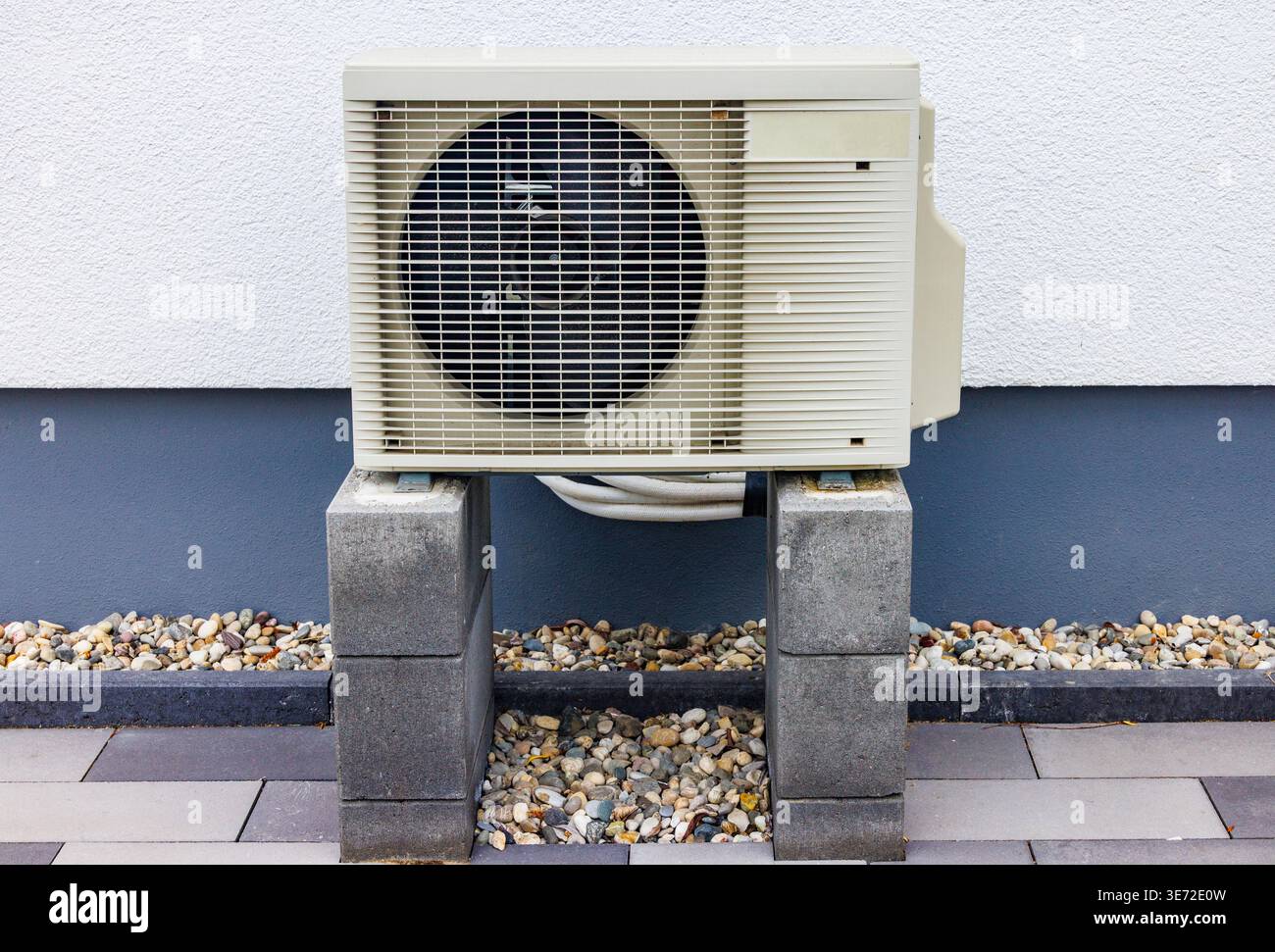 Pompa di calore a sorgente d'aria per il riscaldamento e il raffreddamento all'esterno di una casa residenziale, promuovendo soluzioni energetiche sostenibili Foto Stock
