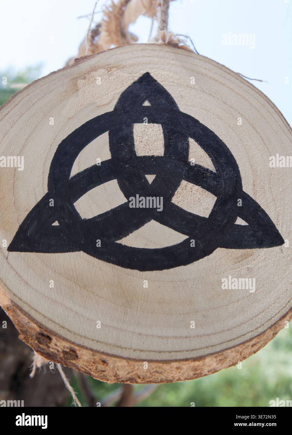 Simbolo di Triquetra dipinto sulla fetta di tronco dell'albero. Ricostruzione del campo militare celtico. Foto Stock