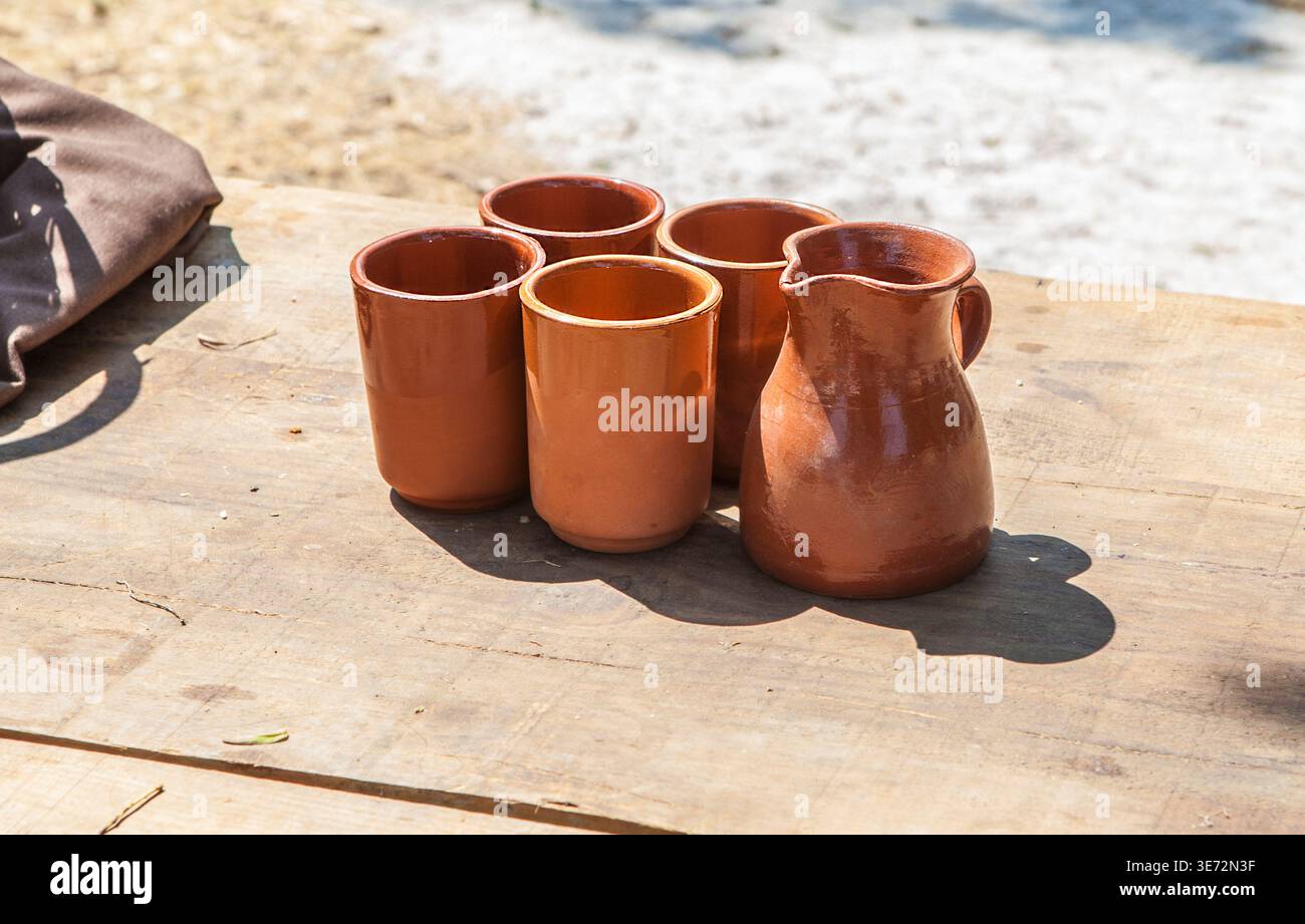 Vetri di argilla esposti su un tavolo di legno. Ricostruzione del campo celtico militare romano. Foto Stock