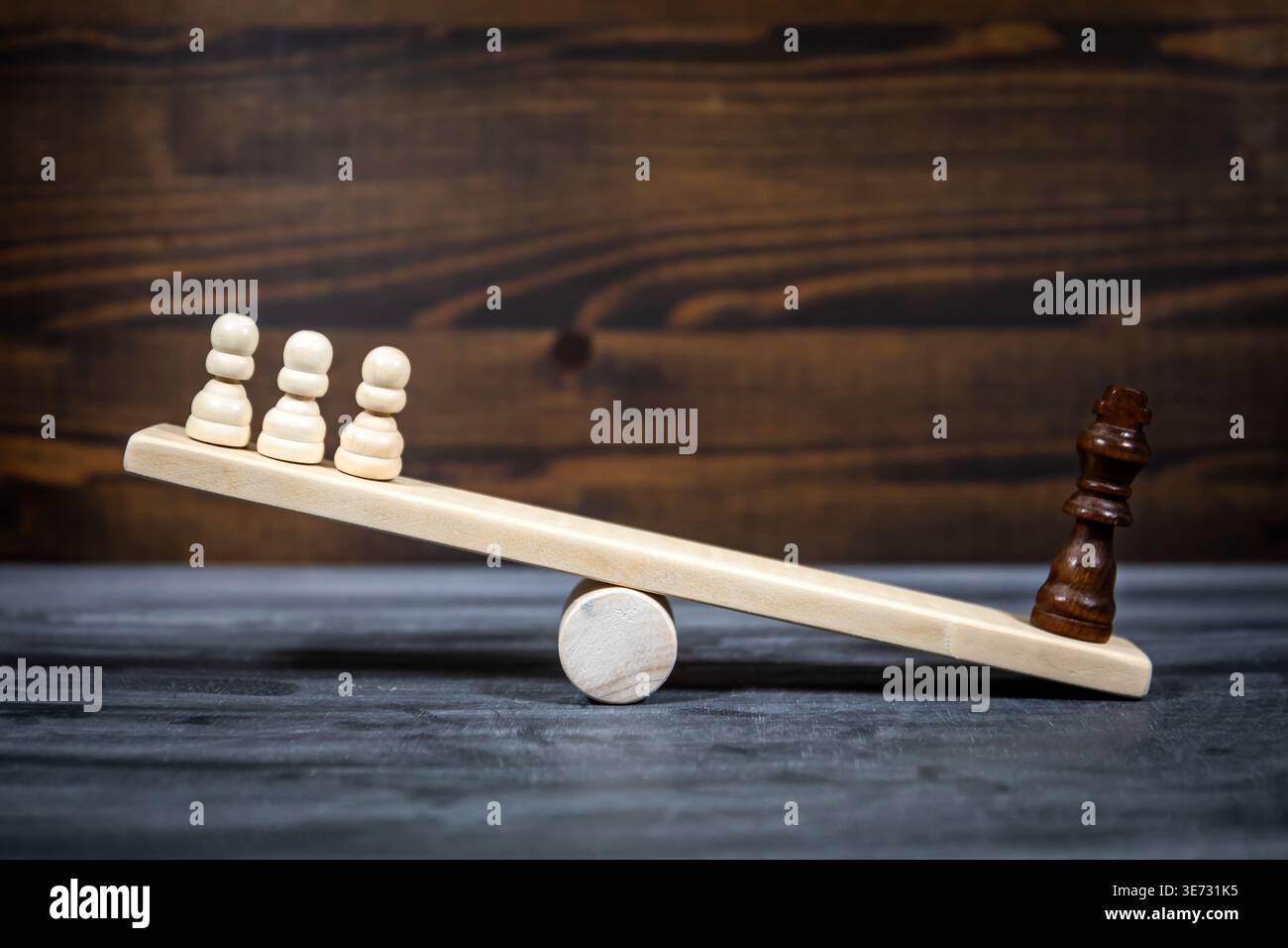 Disuguaglianza sociale e squilibrio di potenza mostrati con figure scacchistiche su Seesaw in legno Foto Stock