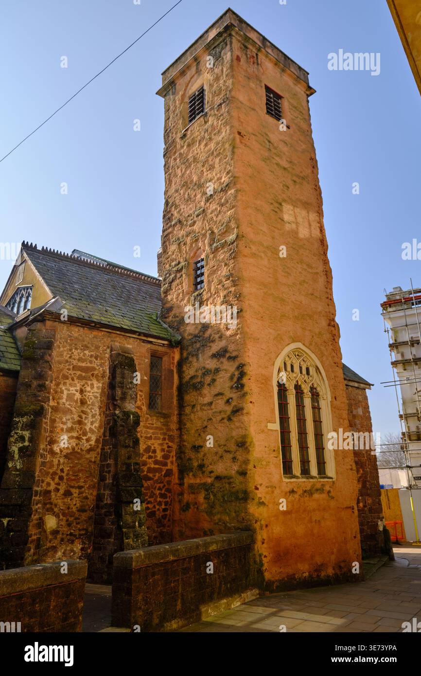 Exeter, Regno Unito - 22 marzo 2026. L'alta torre di arenaria rossa della chiesa di San Martino si innalza ripidamente nel cielo blu primaverile sopra lo storico Foto Stock