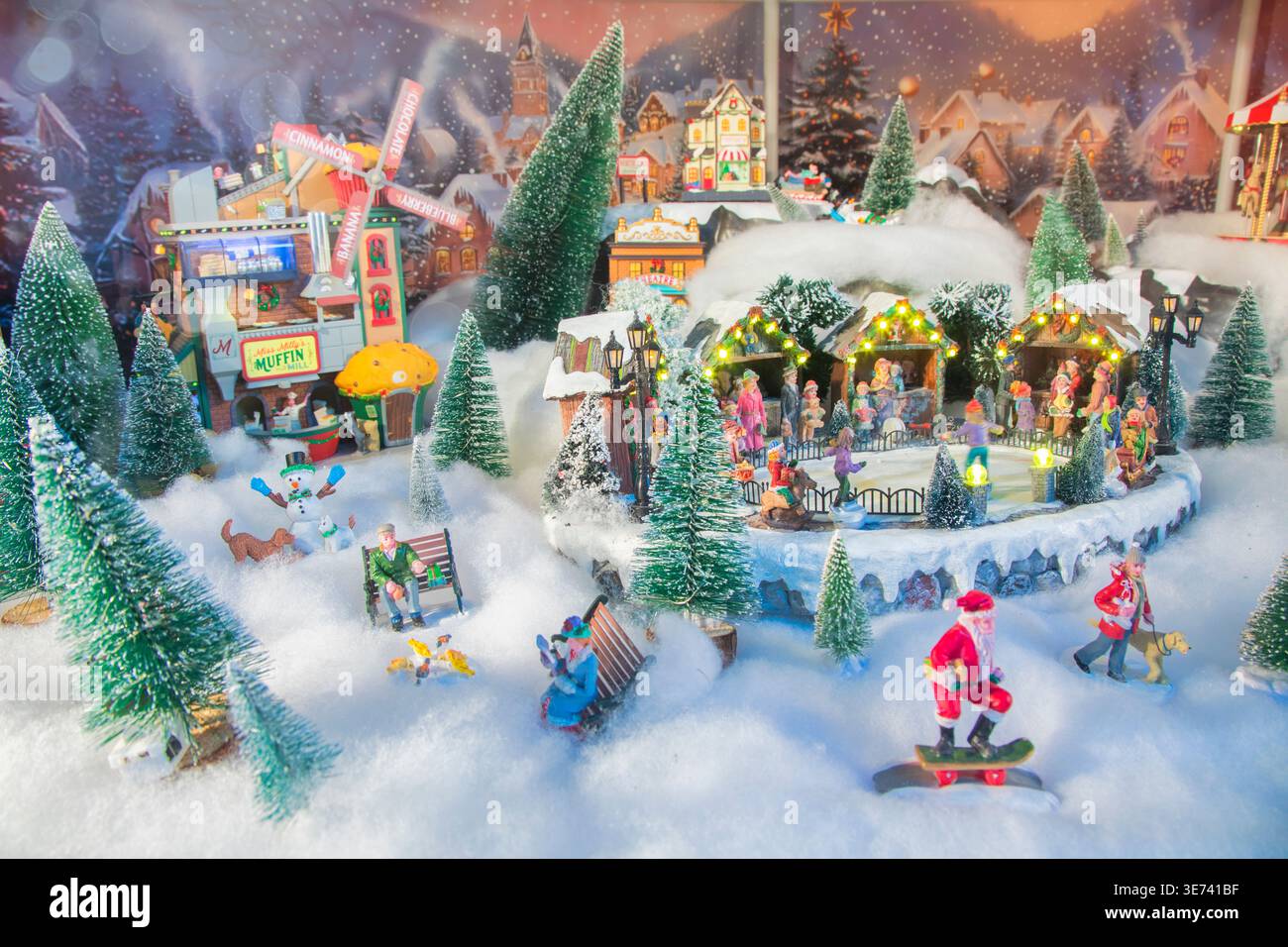 Scena natalizia in miniatura con villaggio innevato, luci e atmosfera natalizia Foto Stock