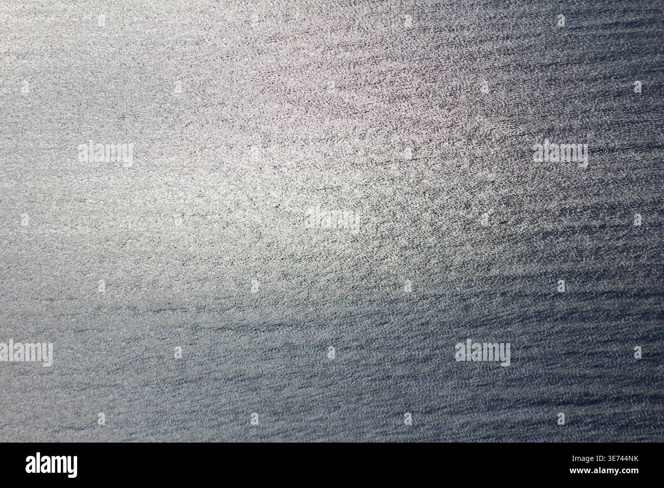 Primo piano della superficie in vetro smerigliato con sfumature di luce sottili e striature morbide, ideale come sfondo astratto o texture. Foto Stock