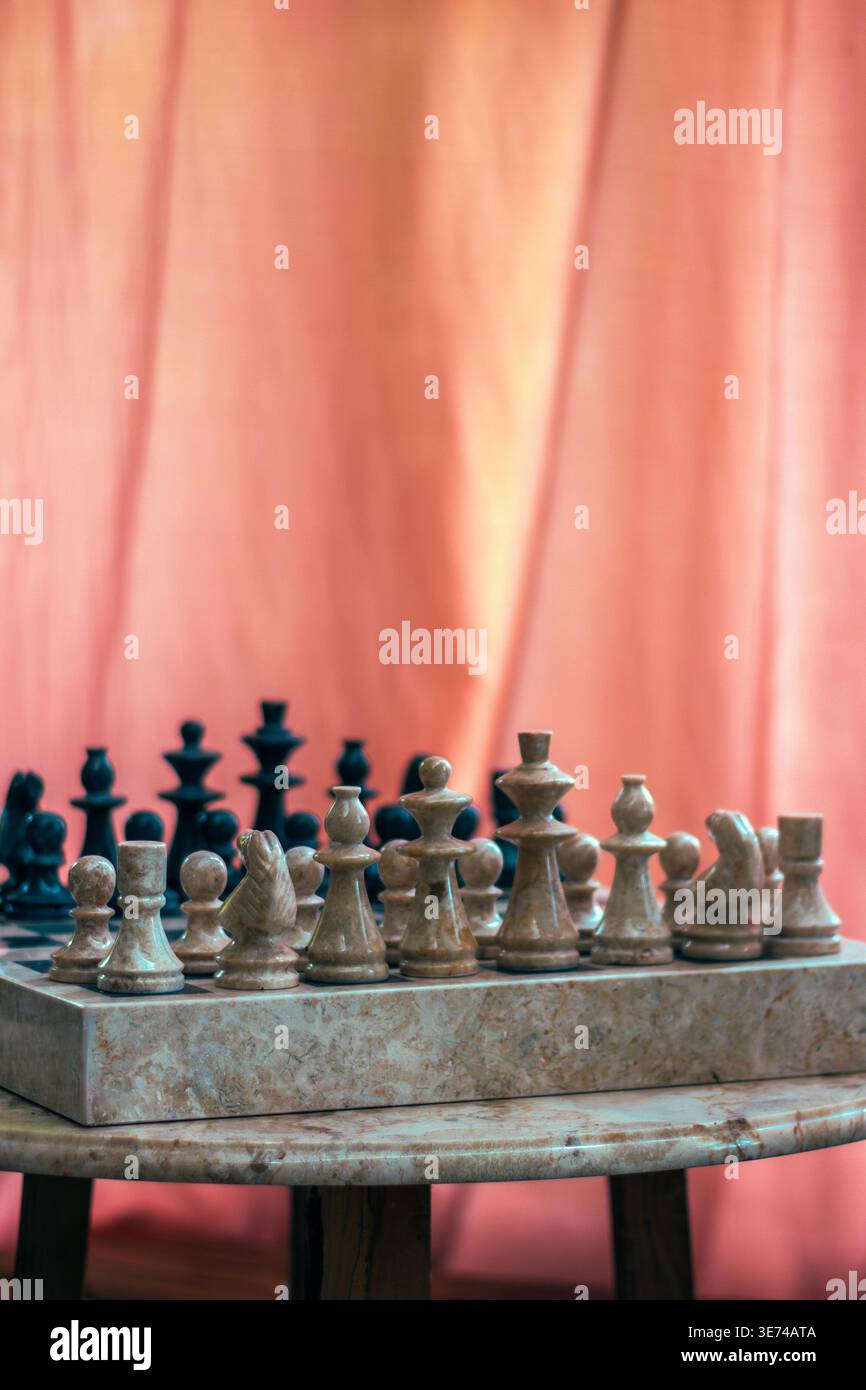 Scacchiera con pezzi illuminati da una luce calda che crea un'atmosfera suggestiva. Simbolo della strategia, della concorrenza e del processo decisionale. Ideale per raccontare storie, Foto Stock