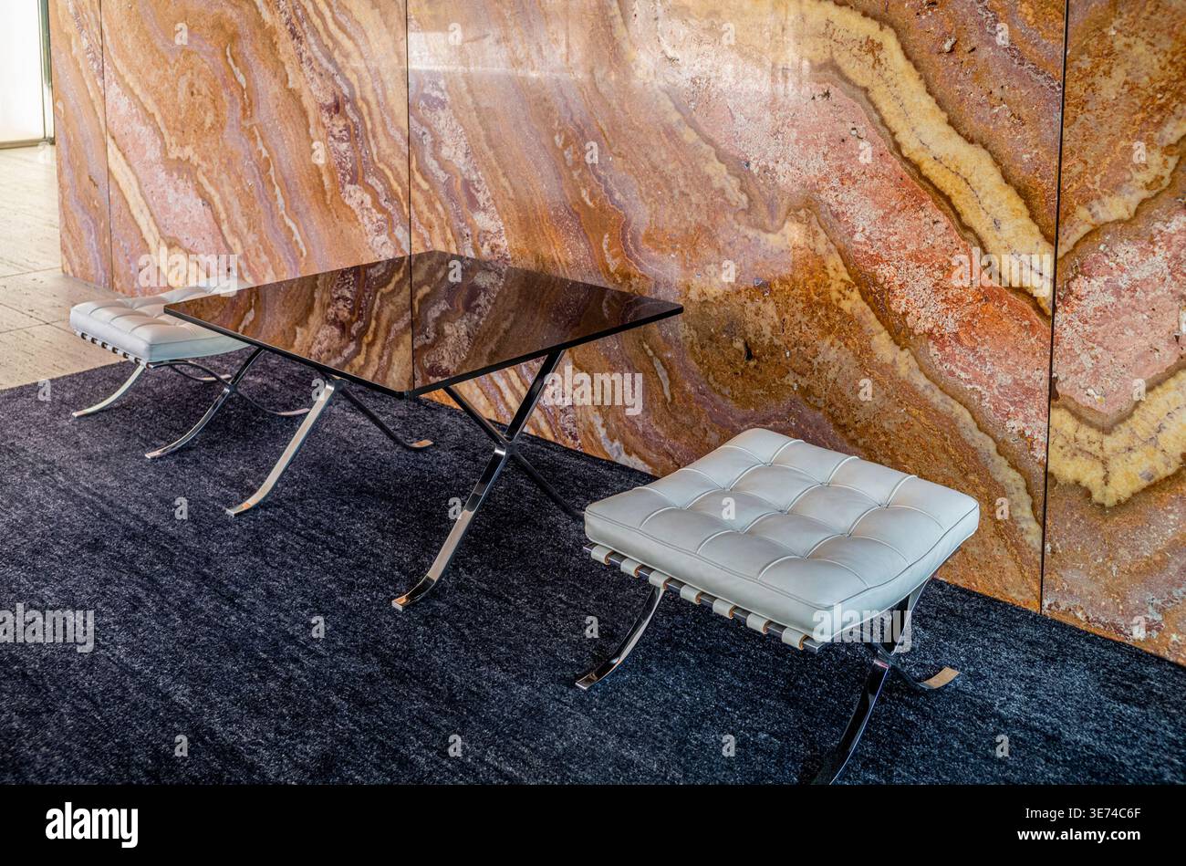 Iconica sedia moderna in pelle bianca e ottomana con splendida parete in marmo dorato Onice Foto Stock