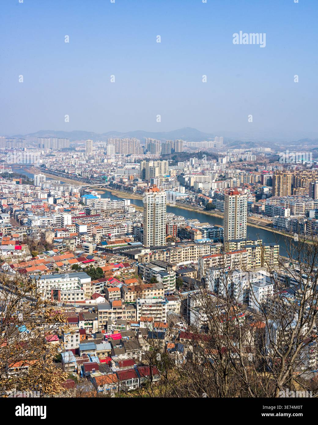 Un'ampia vista sopraelevata su un paesaggio urbano densamente popolato annidato in una valle di montagna, che mette in evidenza un fiume prominente che scorre attraverso il conteggio Foto Stock