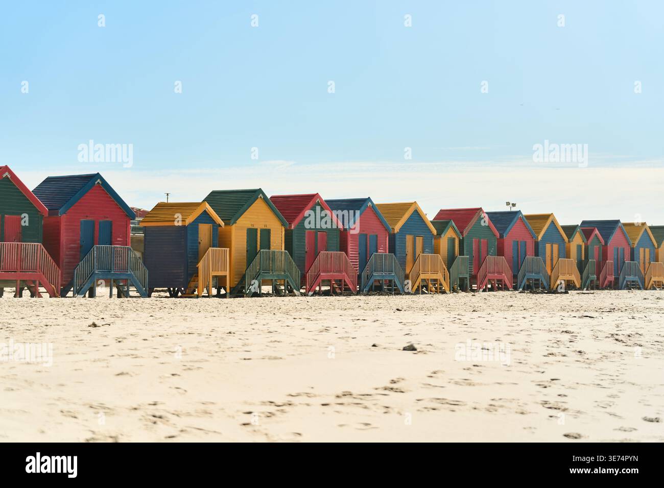 Cabine Vivid Seaside. Colorate capanne lungo la Sandy Coast. Ripari luminosi in legno sulla spiaggia con vista sulle montagne Foto Stock