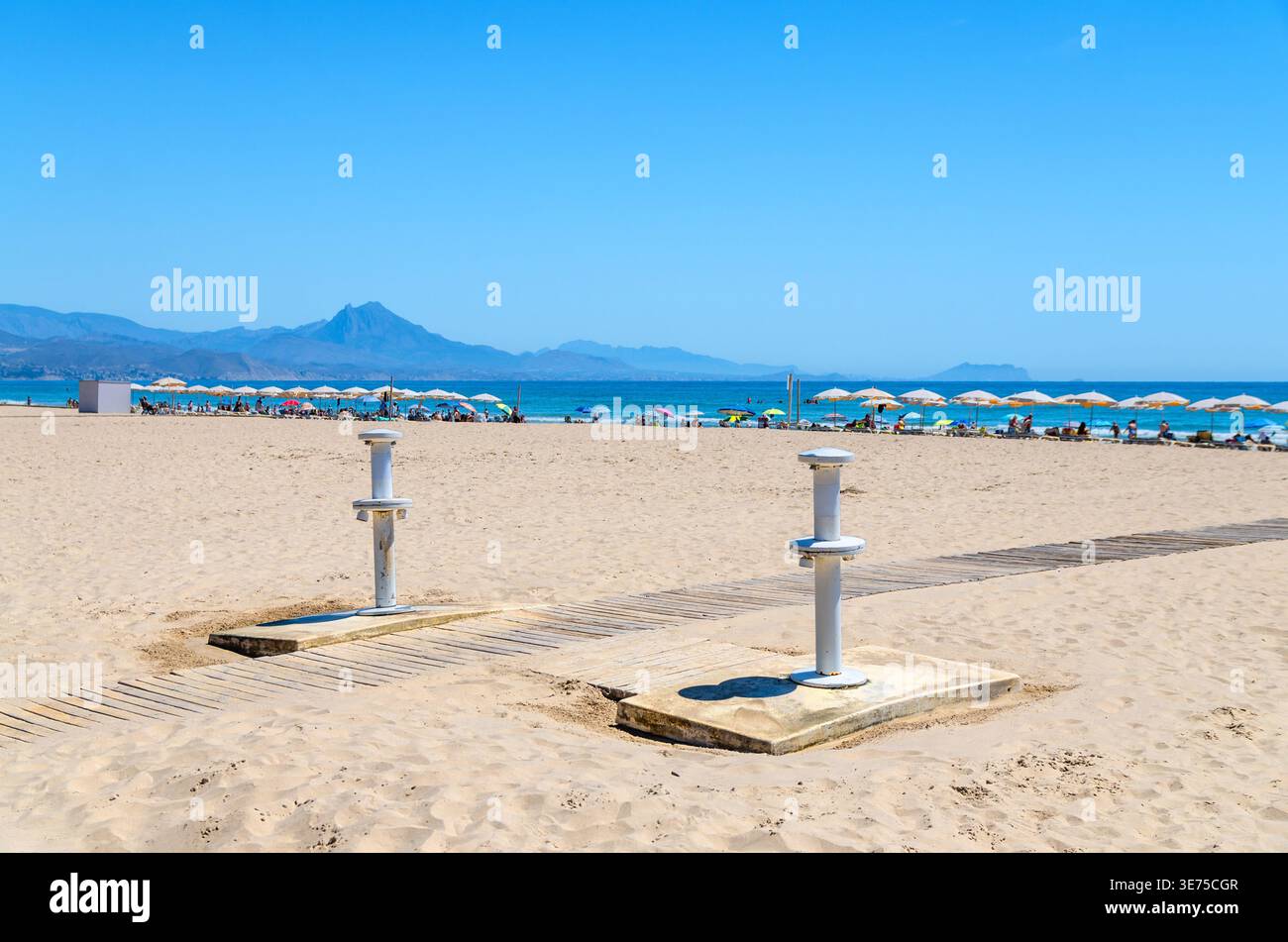Spiaggia di Playa San Juan nella città di Alicante, stazioni di lavaggio dei piedi della spiaggia, docce di risciacquo e passerelle in legno lungo la spiaggia sabbiosa del Mar Mediterraneo Foto Stock