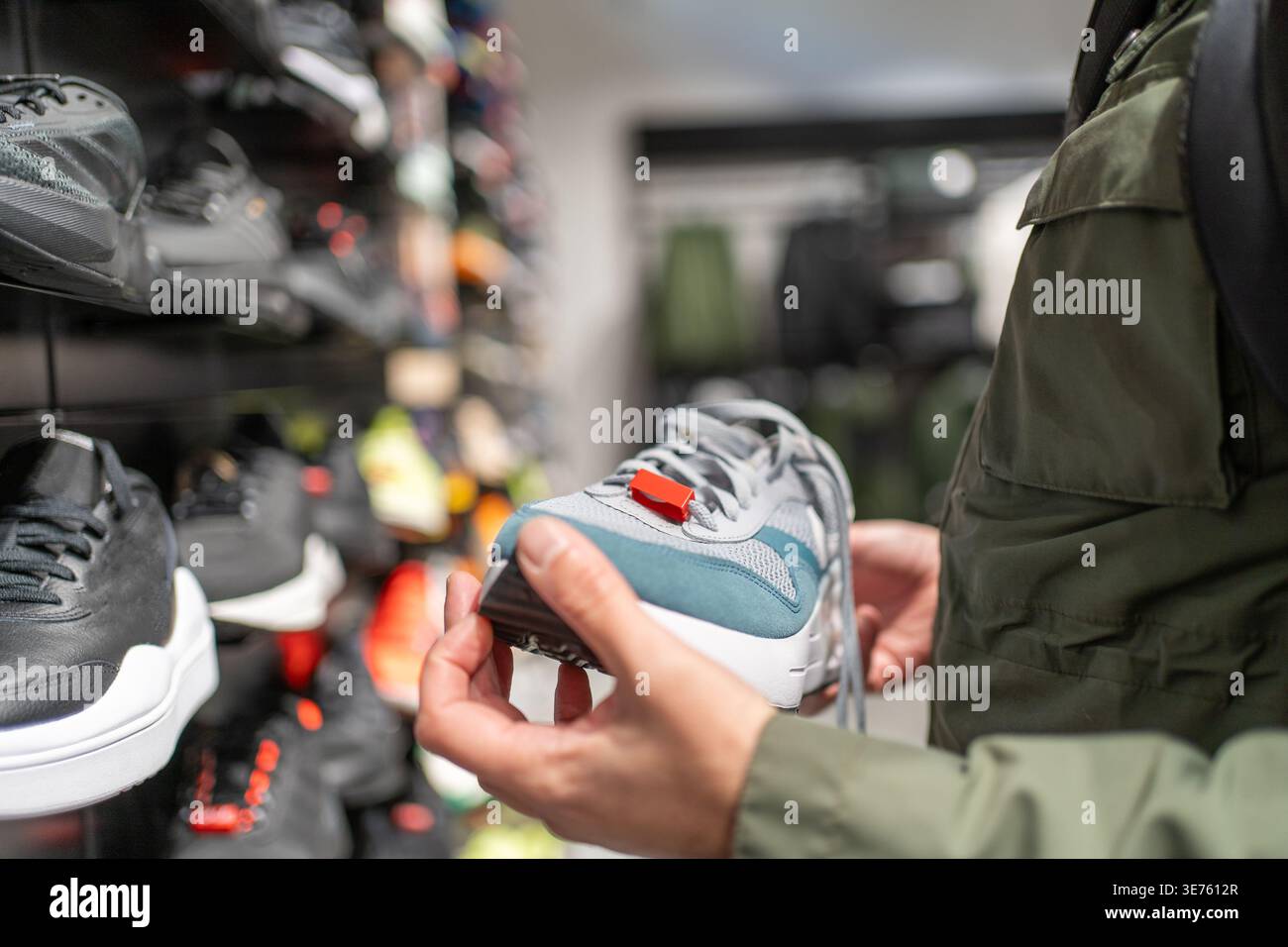 Sneaker shopping, il cliente sceglie le scarpe da running in un negozio sportivo, vendita al dettaglio di calzature, decisione del consumatore, stile di vita attivo, acquisto di moda, confronto dei prodotti. Foto Stock