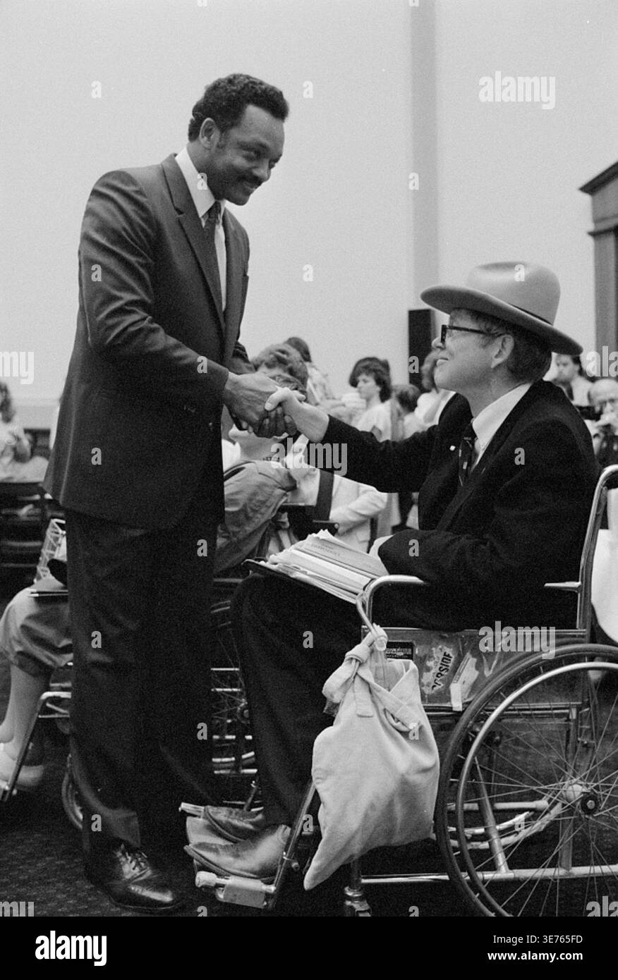 Immagine storica di Jesse Jackson che stringe la mano al difensore dei diritti della disabilità Justin Dart Jr., seduto su una sedia a rotelle, durante un'audizione del Comitato della camera per l'istruzione e il lavoro relativa all'American with Disabilities Act, 17 luglio 1989. Fotografia di R. Michael Jenkins. Foto Stock