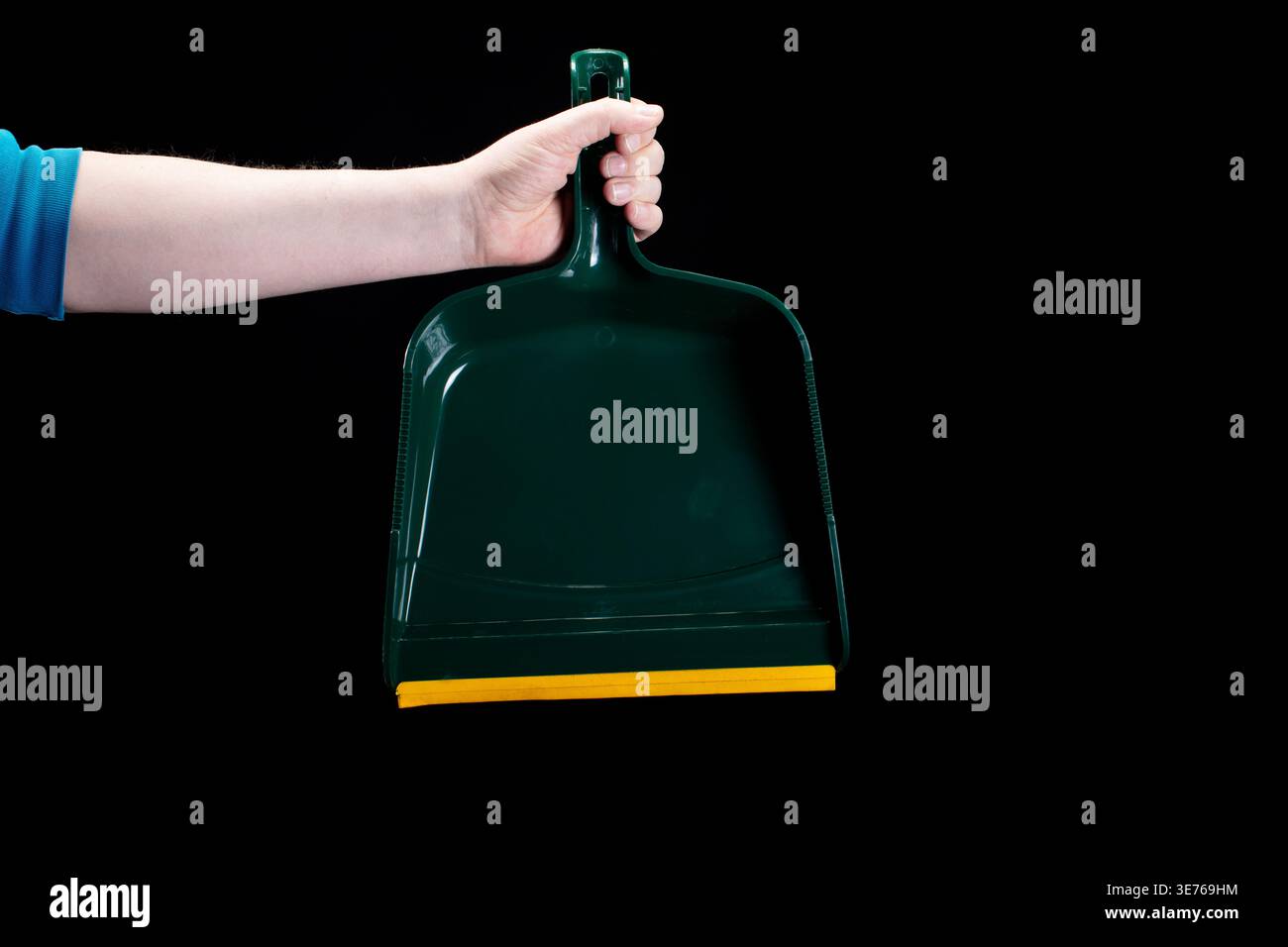 Mano che tiene la paletta verde su sfondo nero Foto Stock