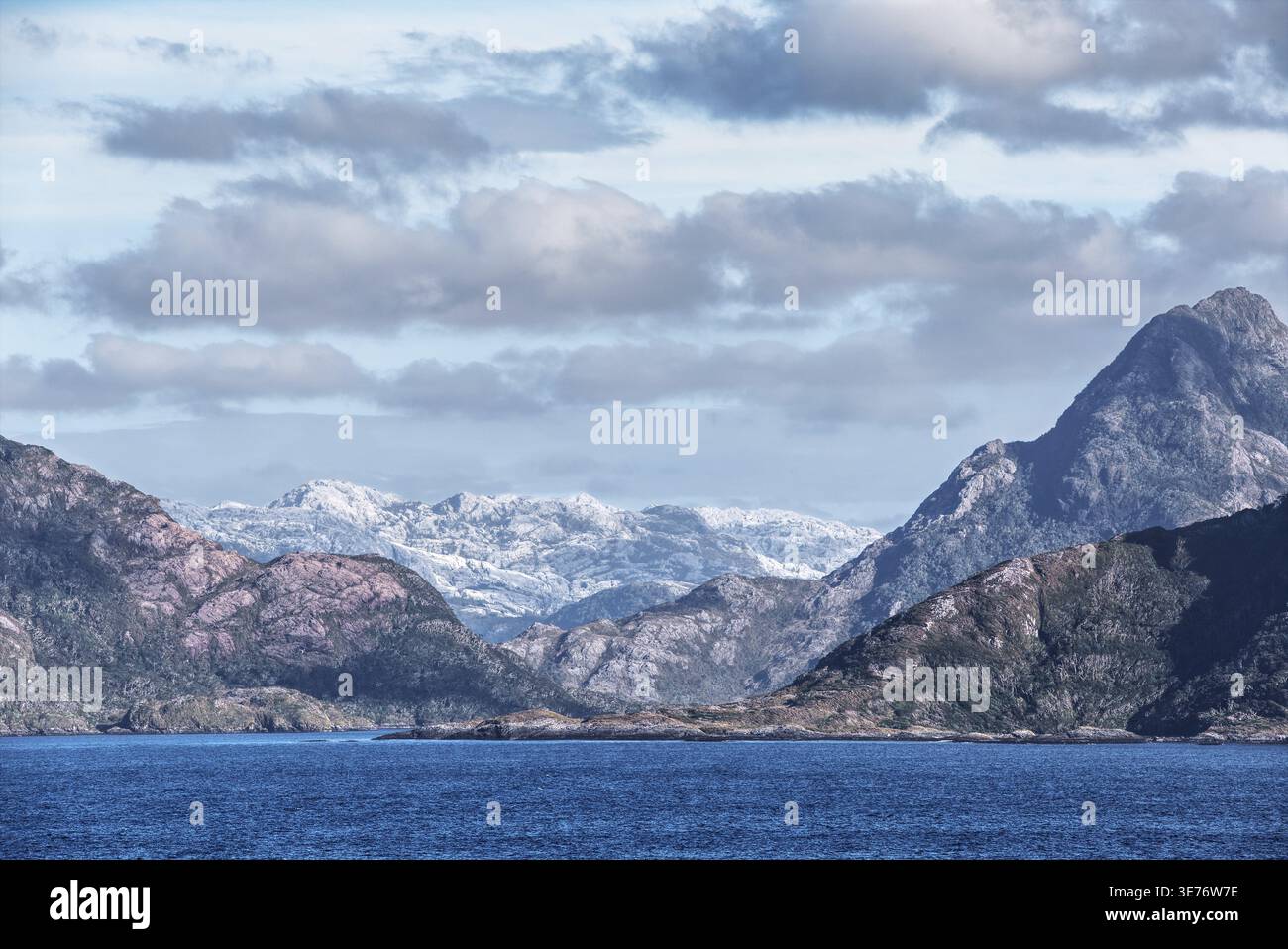 Ampio paesaggio montano con catene montuose di diverse altezze. Dietro le montagne frontali più scure, c'è un massiccio molto chiaro e grigio Foto Stock