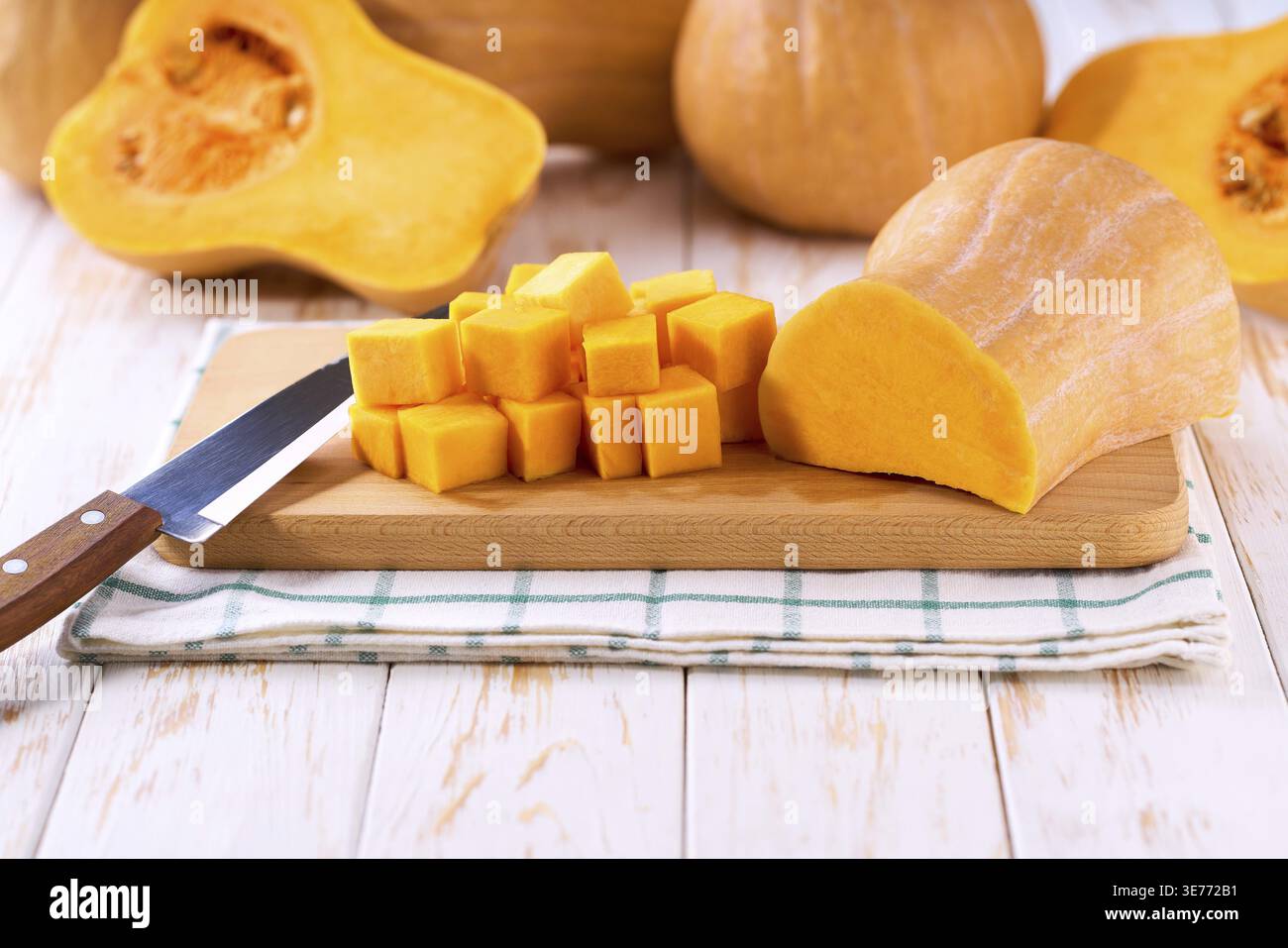 Zucca a cubetti su tagliere in legno spazio per copiare il testo Foto Stock