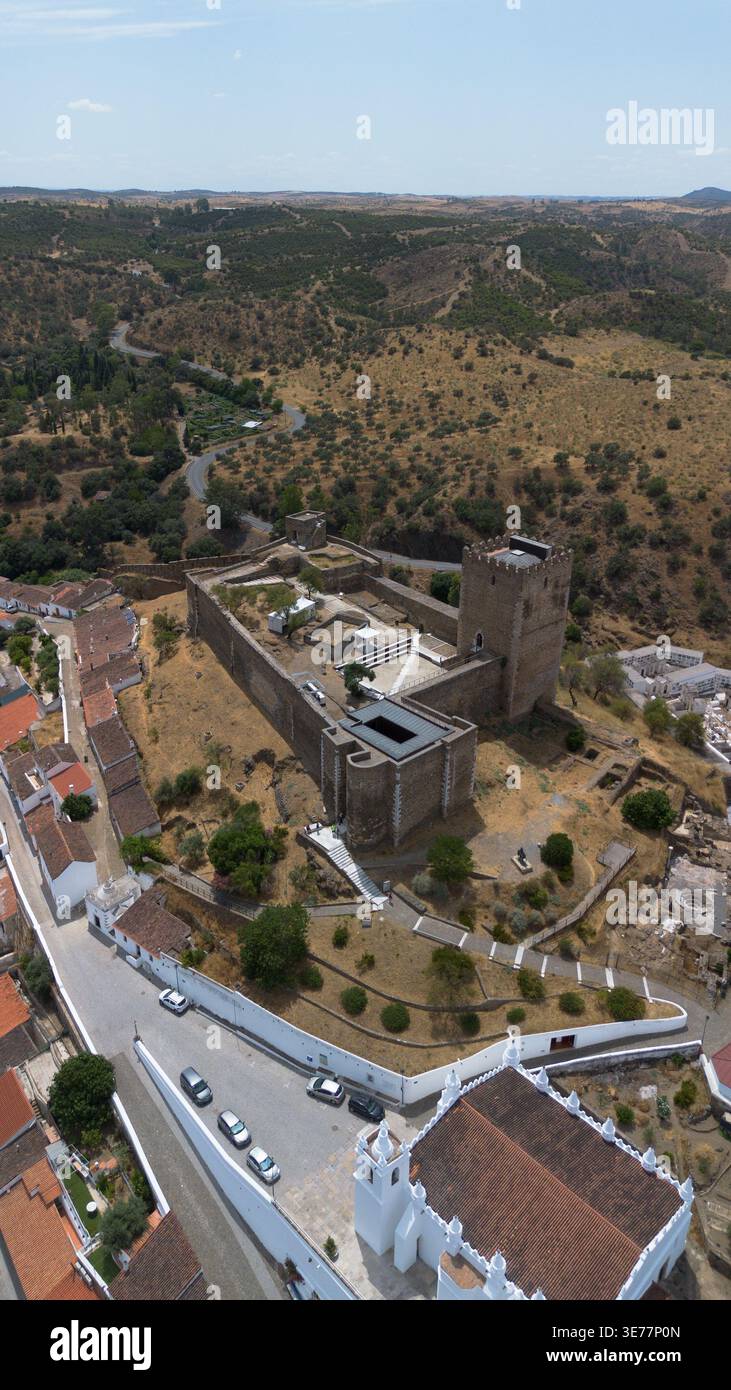Riprese aeree con drone del Castelo de Mértola in Portogallo, una magnifica fortezza medievale sulla cima di una collina con un imponente torre di pietra antica Foto Stock