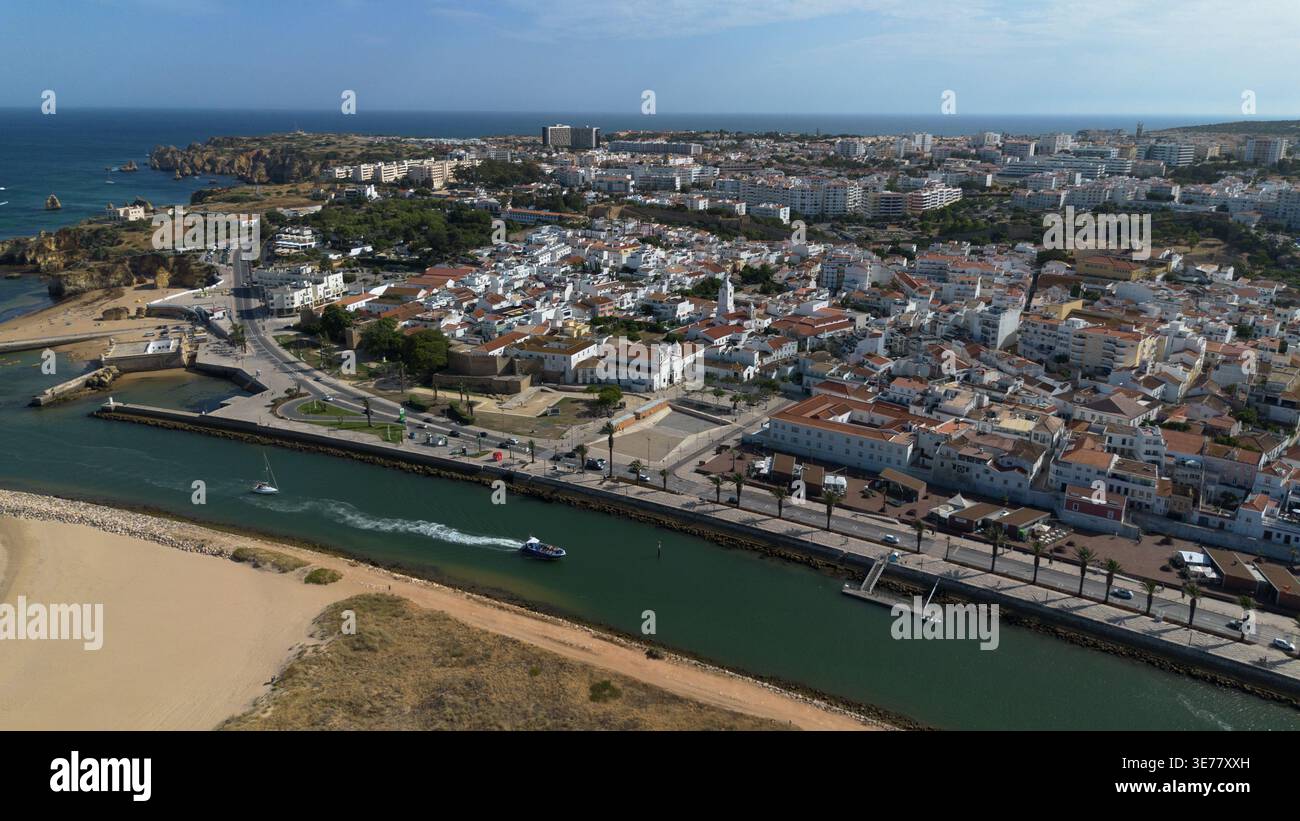 Riprese aeree con drone di Lagos in Portogallo, la magnifica città costiera storica con scogliere di arenaria dorata sorprendenti e spiagge atlantiche pittoresche Foto Stock