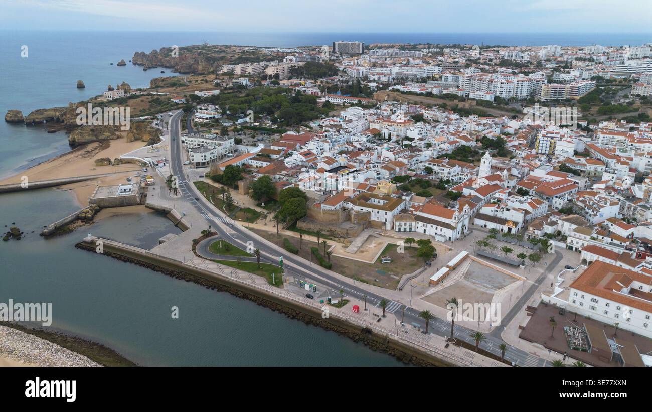 Riprese aeree con drone di Lagos in Portogallo, la magnifica città costiera storica con scogliere di arenaria dorata sorprendenti e spiagge atlantiche pittoresche Foto Stock