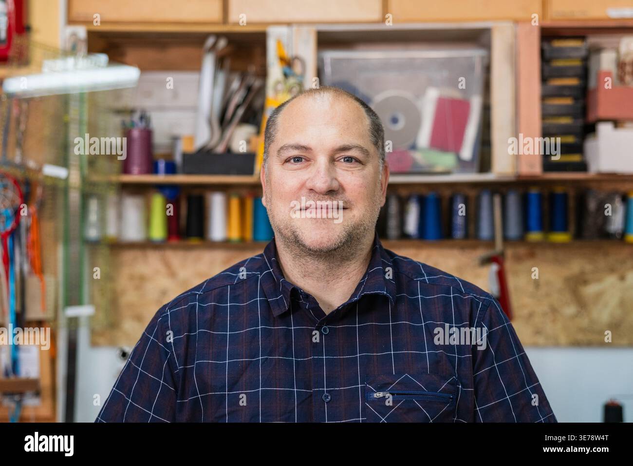 Uomo artigiano sorridente nella sua officina Foto Stock