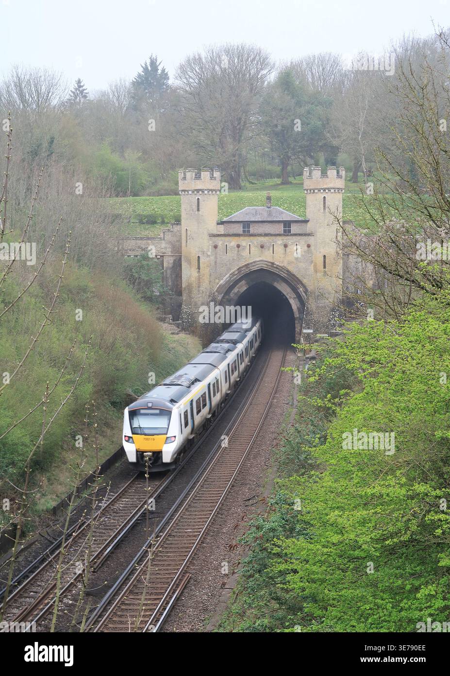 Un treno Thameslink entra nel tunnel ferroviario di Clayton sulla linea Londra-Brighton del Regno Unito. Il portale è famoso per il suo stile castello e il cottage. Foto Stock