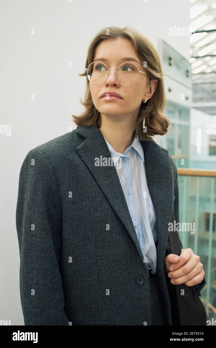 Donna d'affari adulta che indossa gli occhiali per andare in ufficio Foto Stock