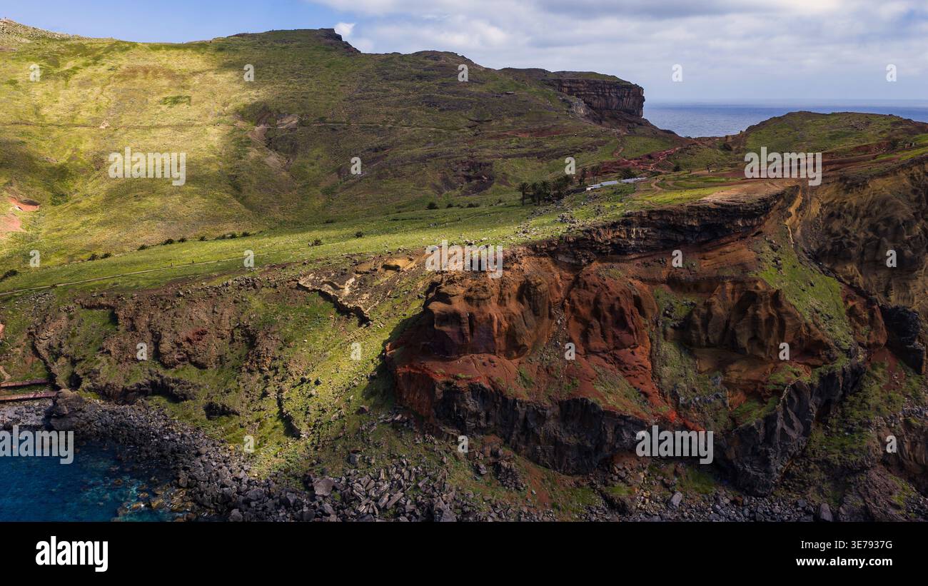 Vista aerea di Ponta de Sao Lourenco, Madeira, con scogliere basaltiche, macchia verde, palme, sentieri, escursionisti, spiagge di massi e nuvole di pomeriggio Foto Stock